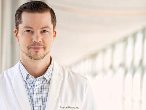 This is a photo of Dr. Austin Hayes wearing a physician's white coat. 